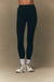 Person wearing navy leggings and white sneakers on a beige background <model-info>Jelene wears a size XS and is 5’7”, 23” waist, 32AB bust.</model-info>