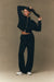 Person wearing a black outfit against a brown background <model-info>Jelene wears a size XS and is 5’7”, 23” waist, 32AB bust.</model-info>