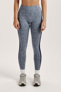 Woman wearing a gray athletic outfit with a sports bra and leggings on a white background 