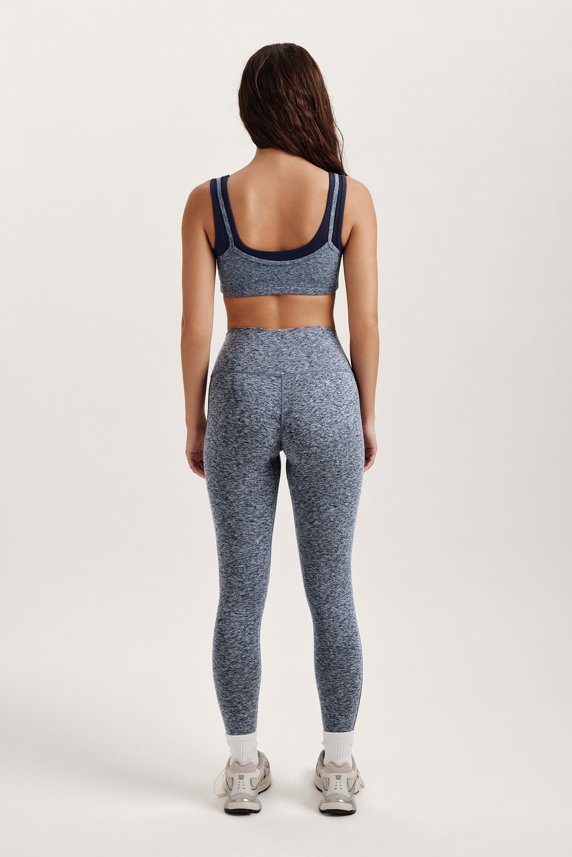 Person wearing a blue and gray athletic outfit on a white background