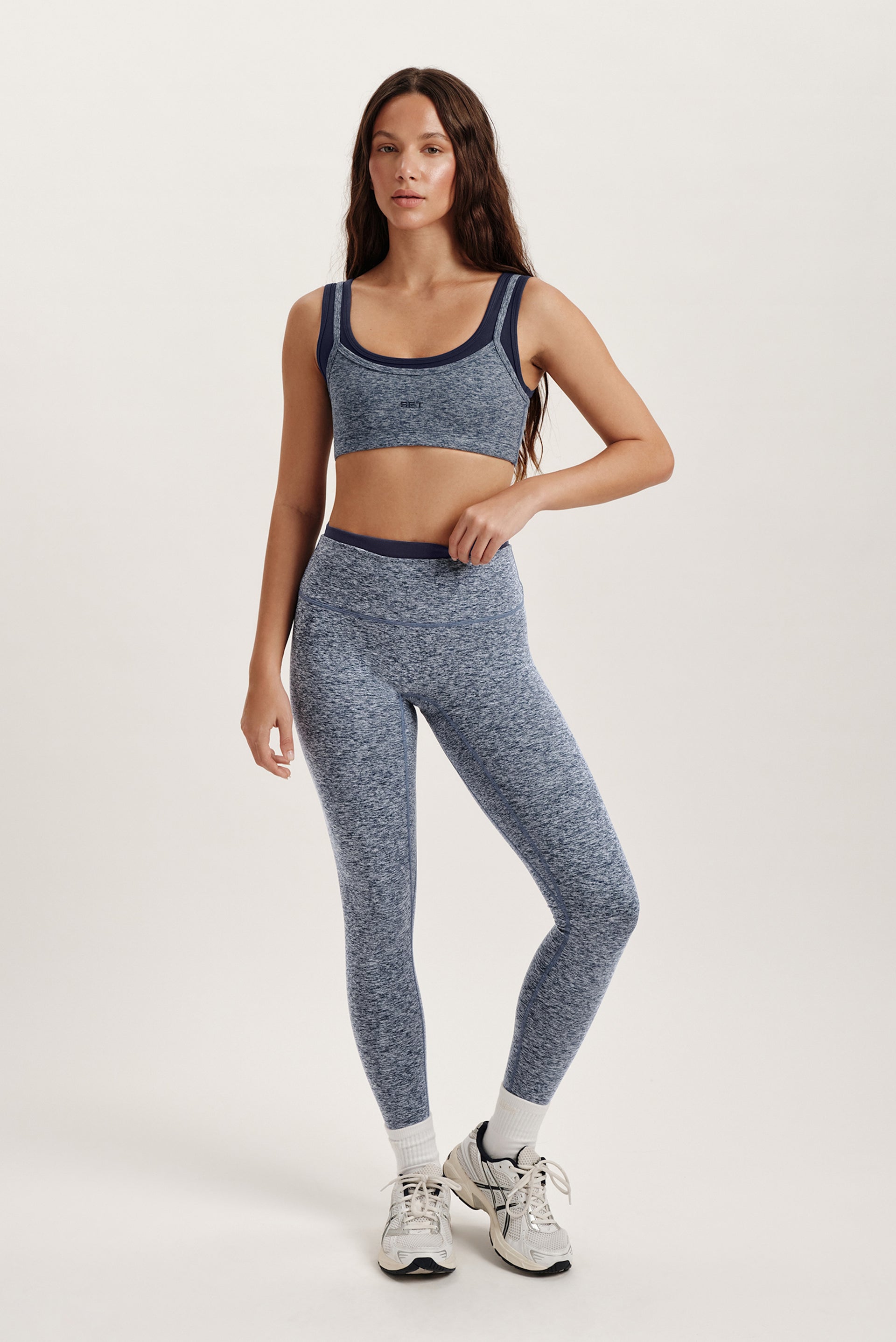 Woman wearing a blue athletic outfit on a white background