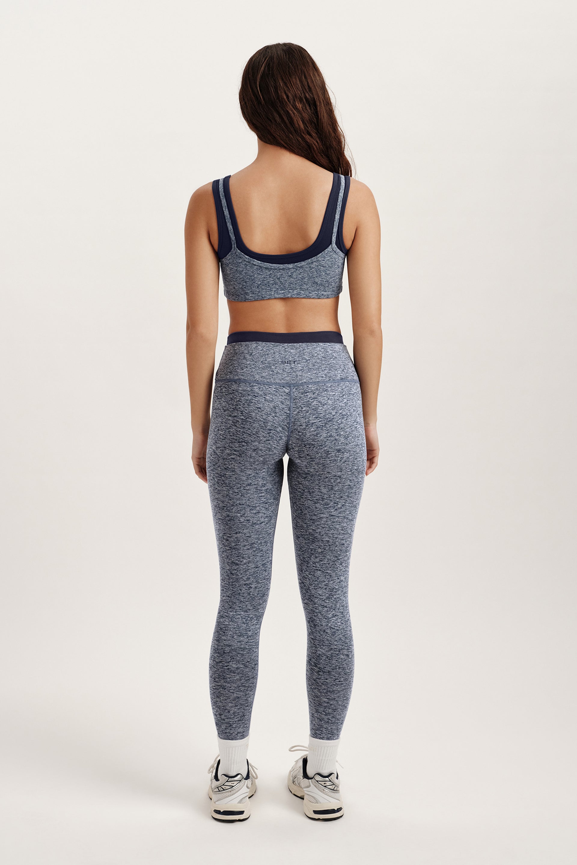 Person wearing a gray athletic outfit on a white background