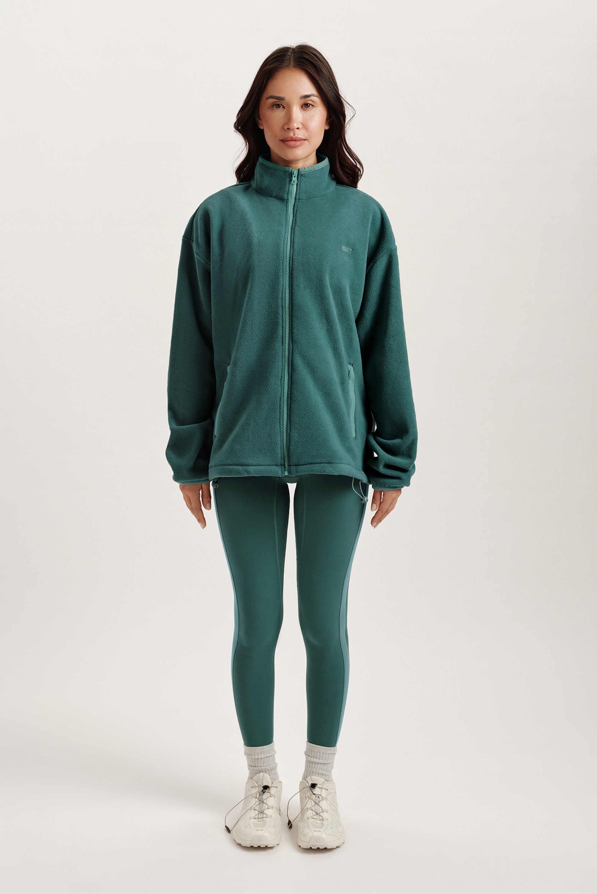 Person wearing a green tracksuit on a white background