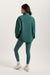 Person wearing a teal tracksuit on a white background