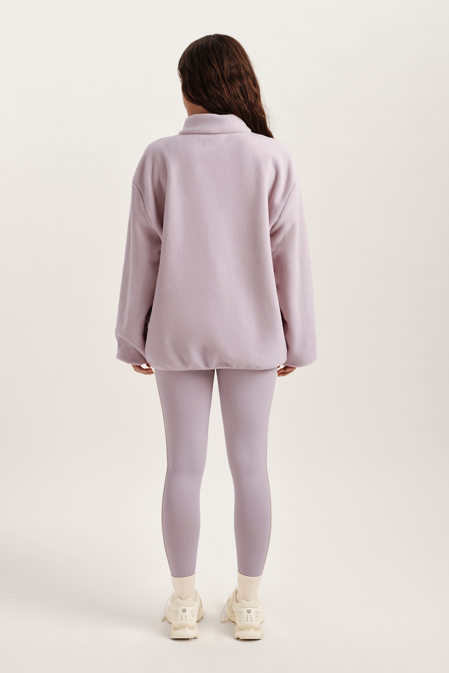 Person wearing a light purple outfit on a white background