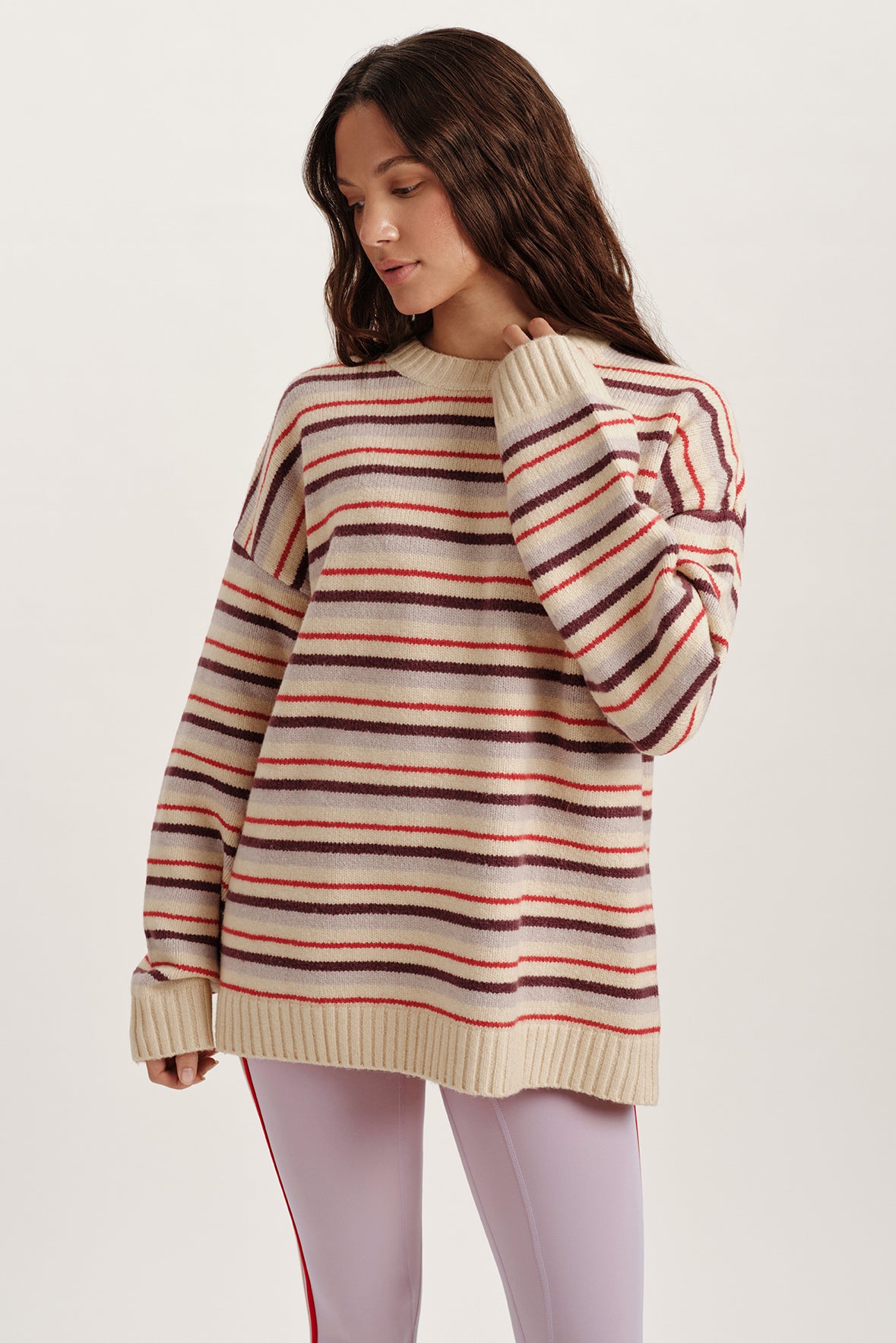 Woman wearing a striped sweater on a plain background