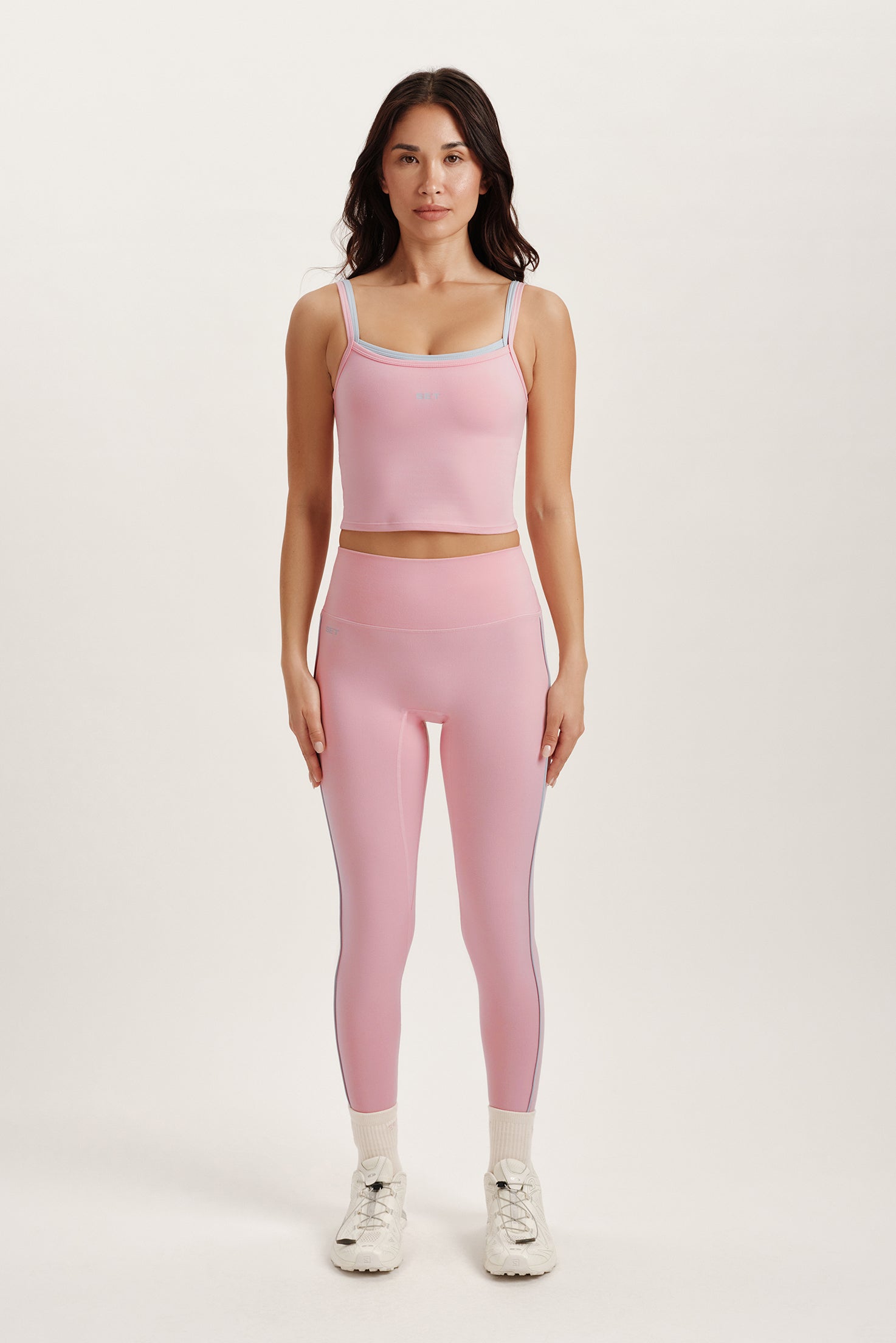 Woman wearing a pink athletic outfit on a white background
