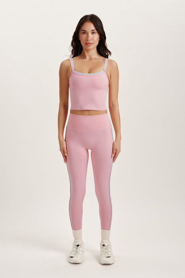 Woman wearing a pink athletic outfit on a white background