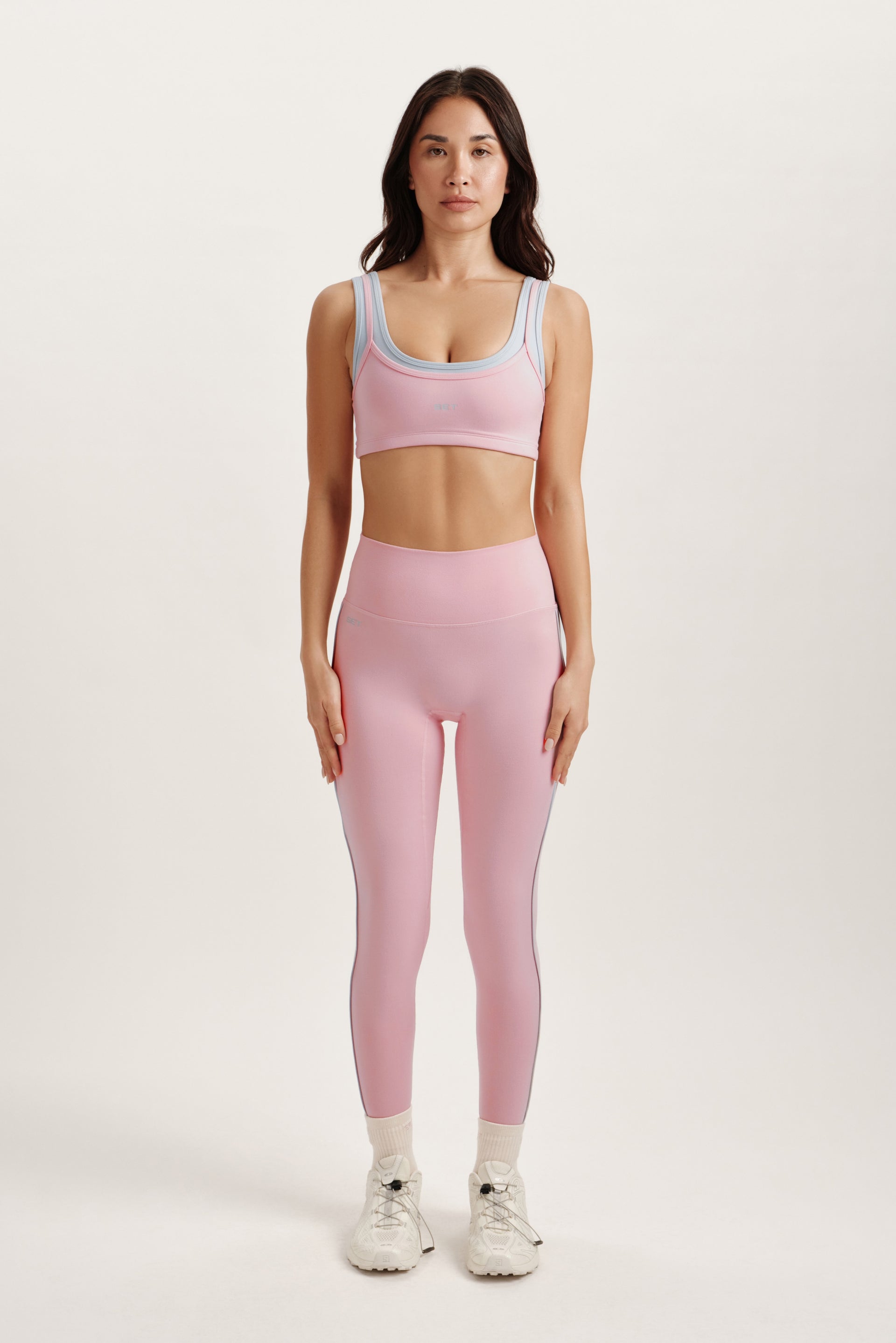 Woman wearing a pink athletic outfit on a white background