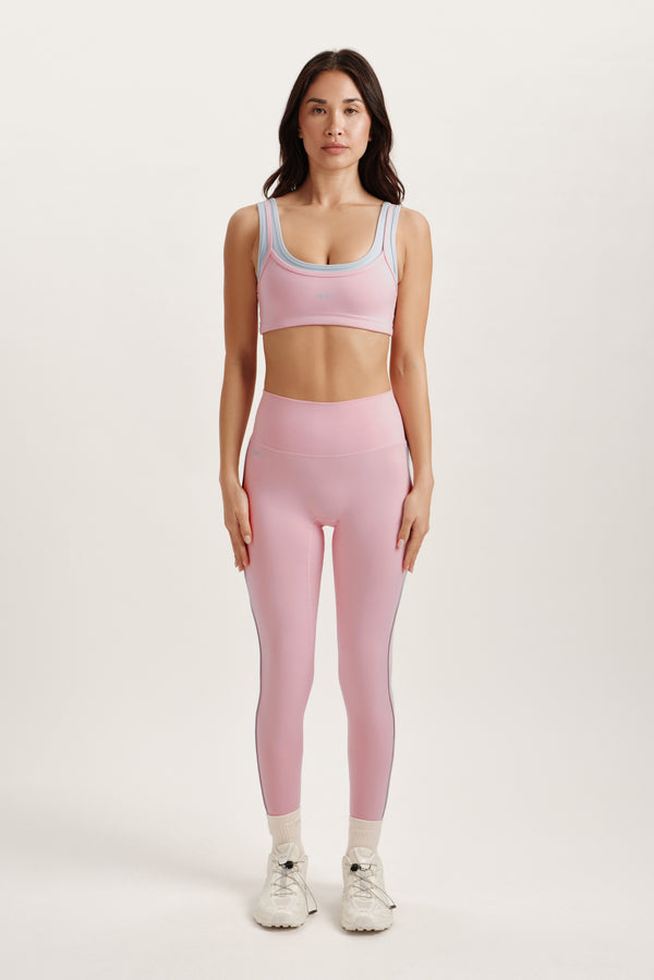 Woman wearing a pink athletic outfit on a white background