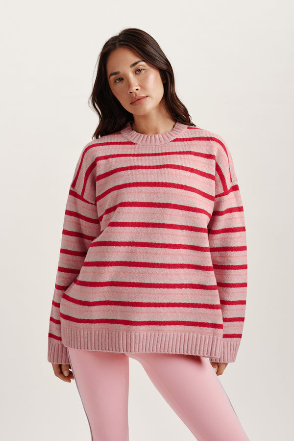 Woman wearing a pink and red striped sweater on a white background