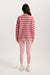 Person wearing a red and white striped sweater and pink leggings on a white background