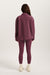 Person wearing a maroon tracksuit on a white background