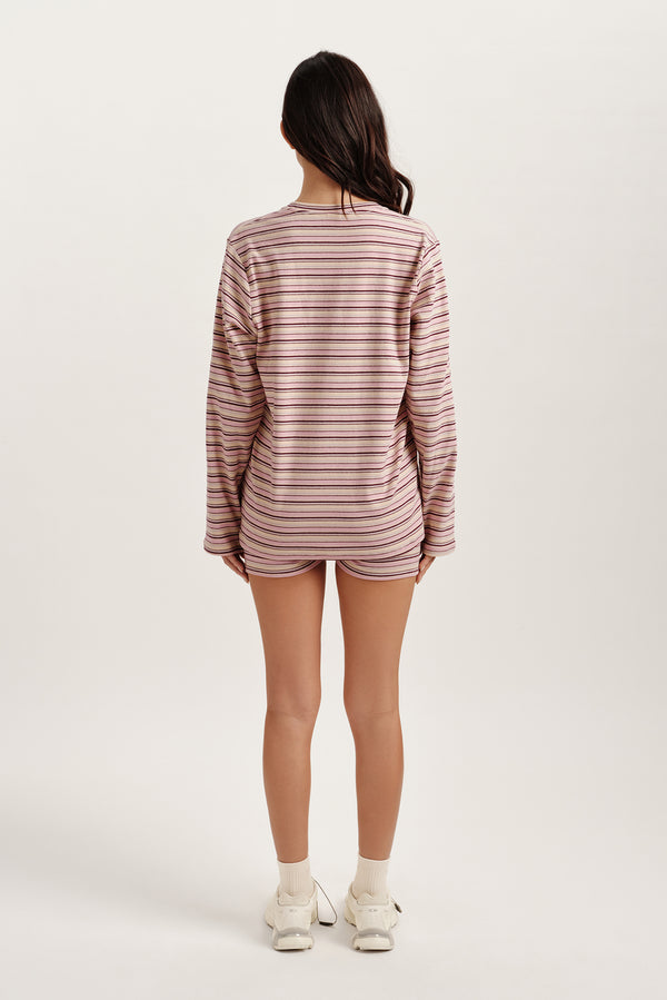 Person wearing a striped long-sleeve shirt and shorts on a white background