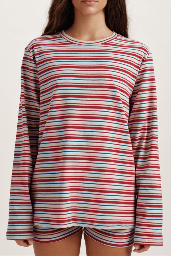 Person wearing a red and white striped long-sleeve shirt on a plain background