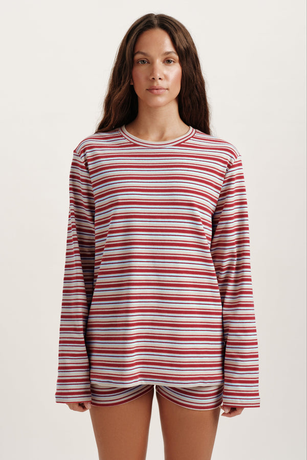 Woman wearing a red and white striped long-sleeve shirt on a beige background