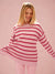 Woman wearing a pink and red striped sweater on a pink background