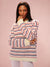 Woman wearing a striped sweater against a pink background