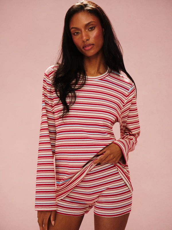 Woman wearing a red and white striped outfit on a pink background