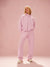 Person wearing a pink tracksuit against a pink background