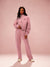 Woman wearing a pink tracksuit with 'SET' branding on a pink background