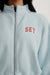Light blue jacket with 'SET' embroidered on the chest against a white background