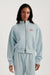 Woman wearing a light blue tracksuit with 'SET' logo on a white background