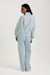 Person wearing a light blue tracksuit on a white background