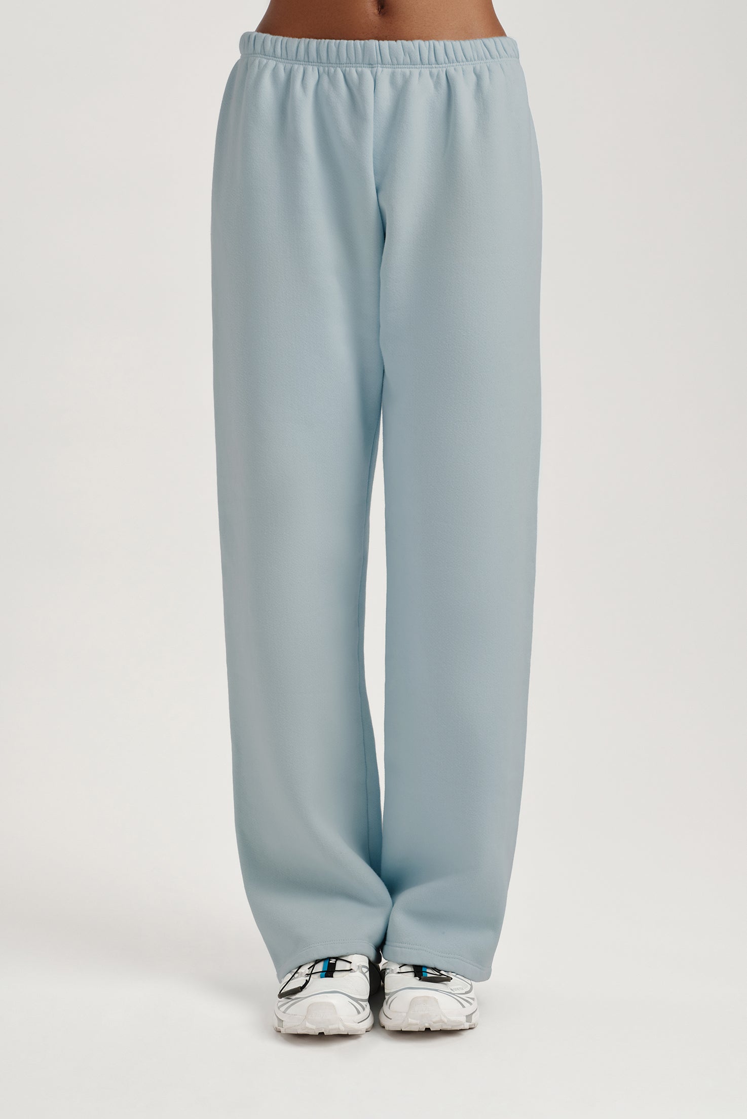 Light blue sweatpants worn by a person on a light gray background