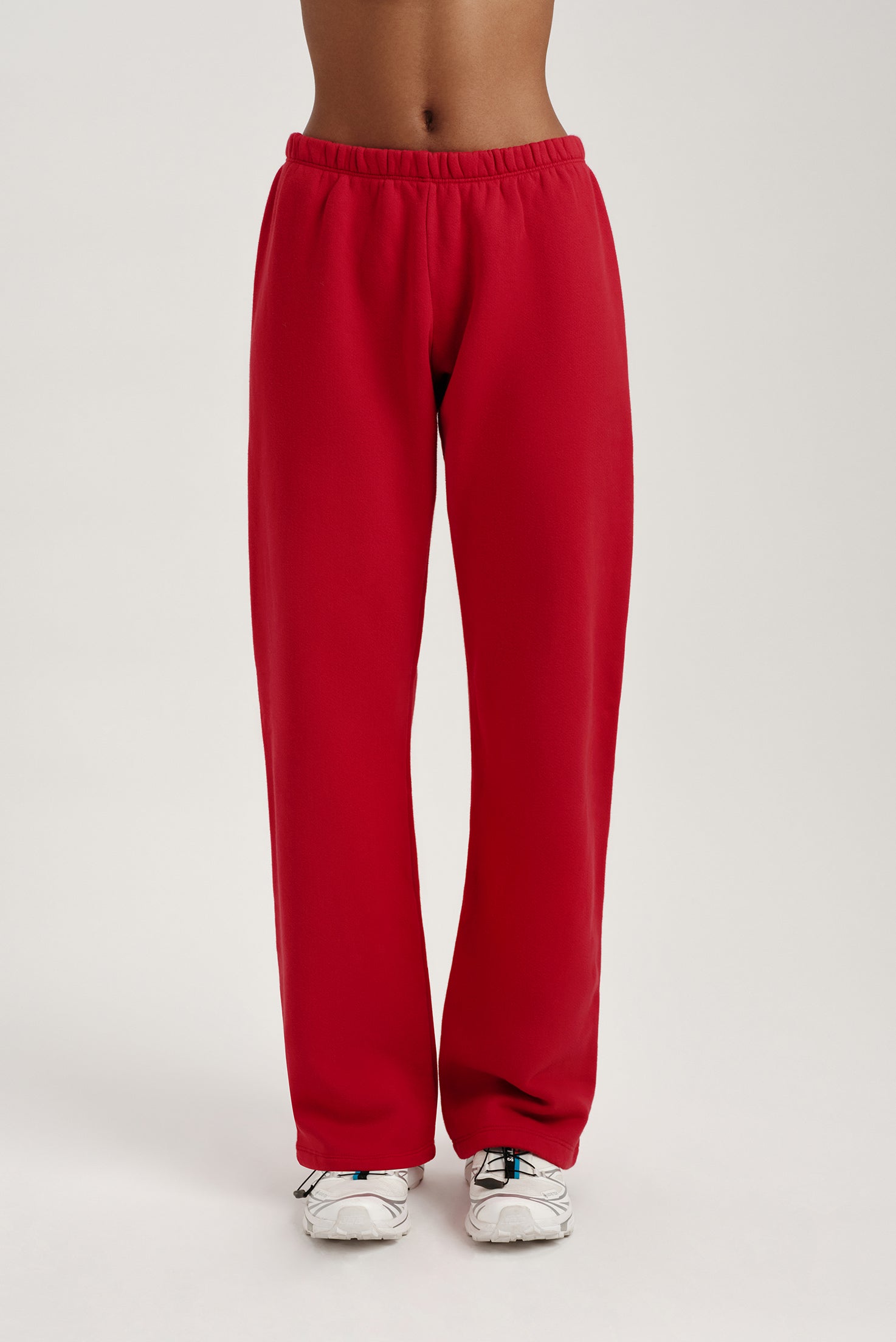 Red sweatpants worn by a person on a light gray background