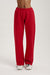 Red sweatpants worn by a person on a light gray background
