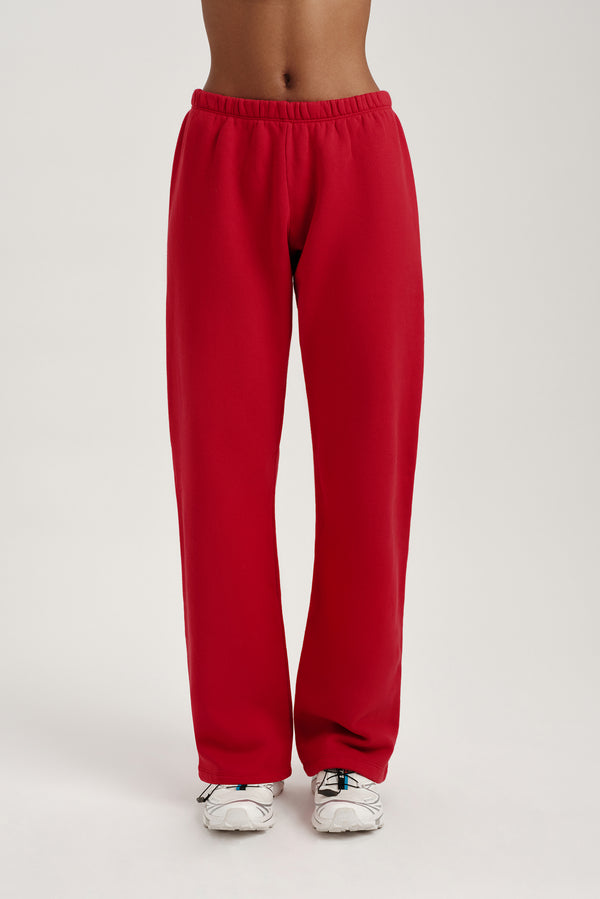 Red sweatpants worn by a person on a light gray background