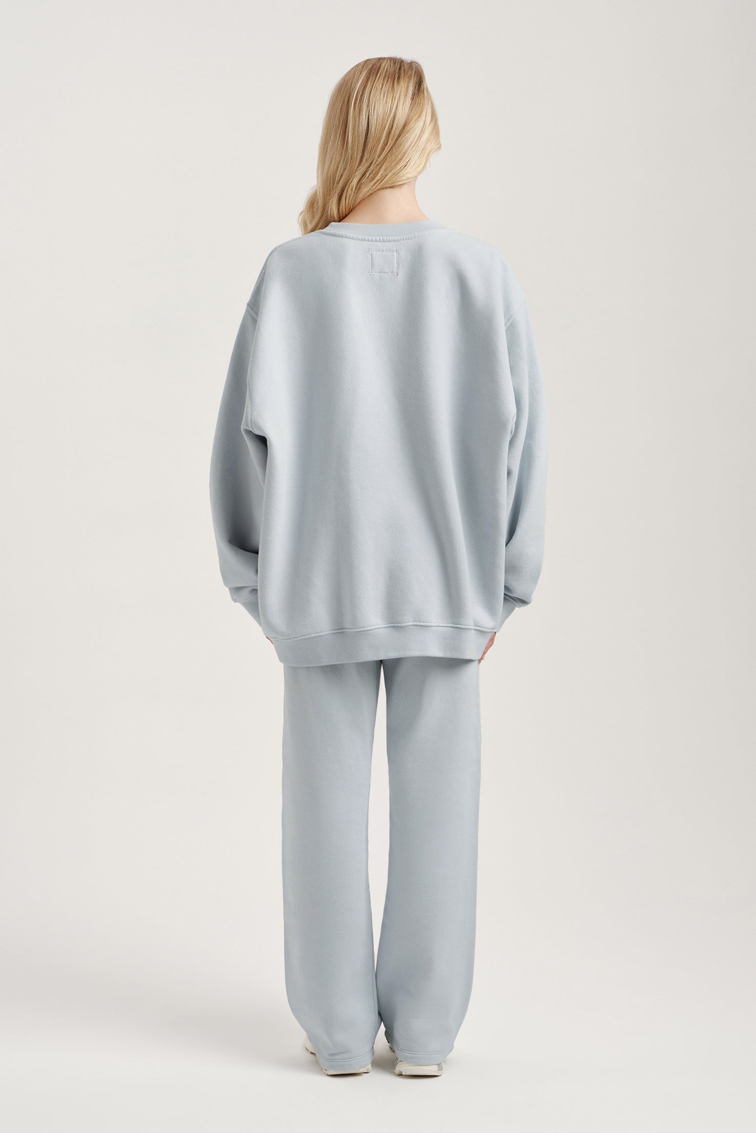 Person wearing a light blue outfit on a plain background