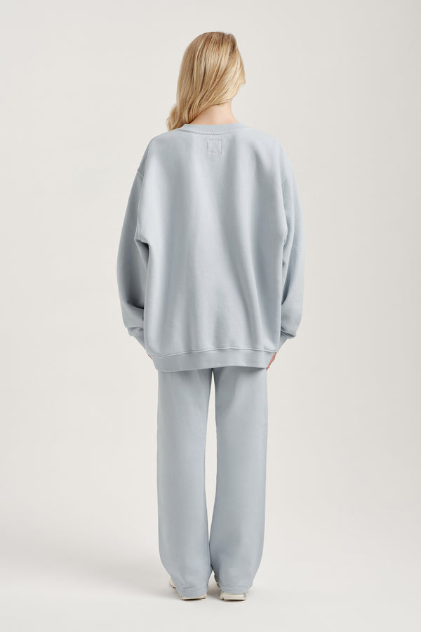 Person wearing a light blue outfit on a plain background