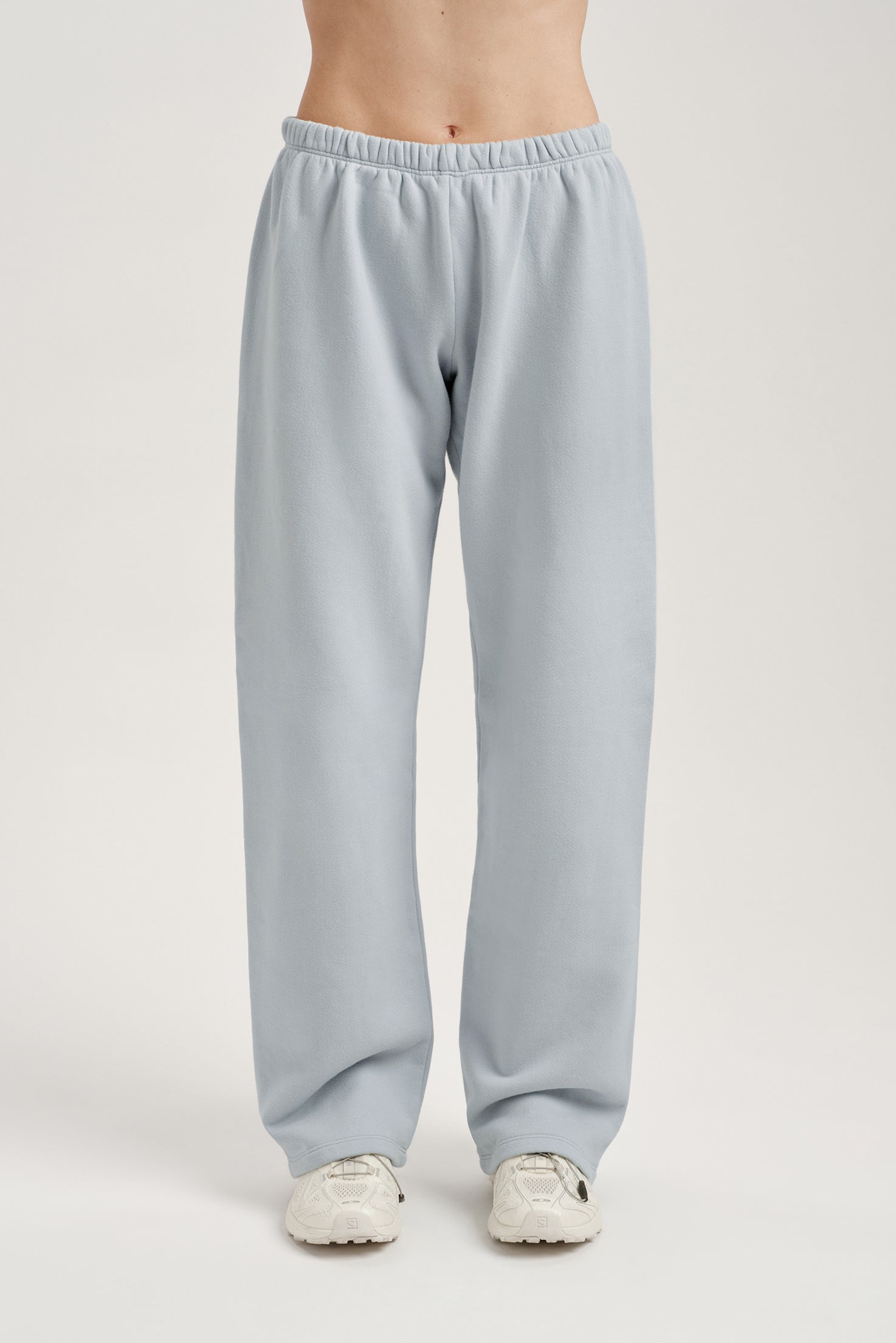Light blue sweatpants worn by a person on a white background