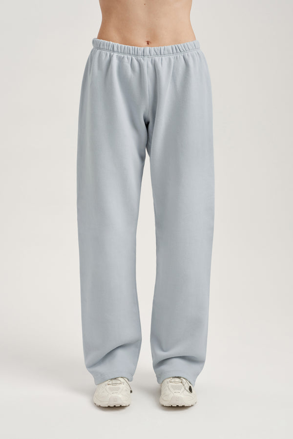Light blue sweatpants worn by a person on a white background