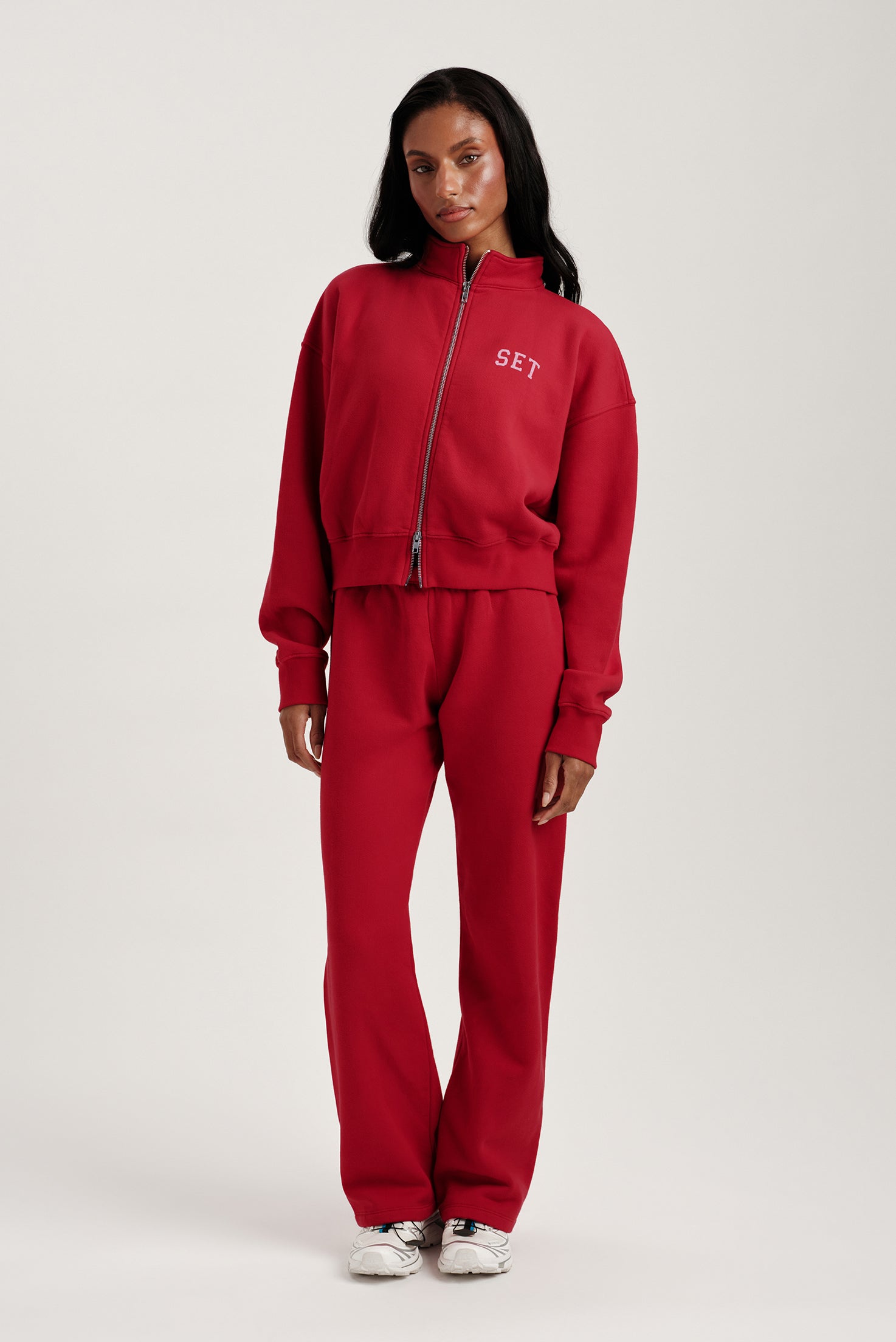 Person wearing a red tracksuit with 'SET' branding on a white background