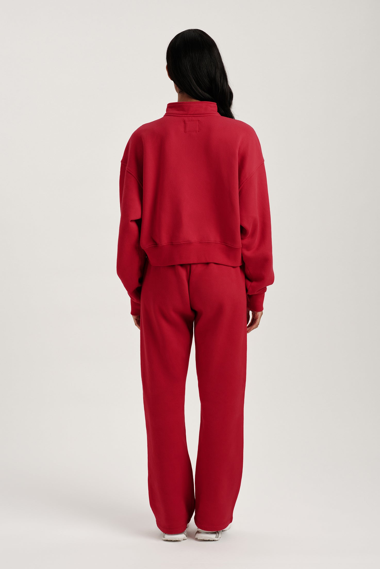 Person wearing a red tracksuit on a white background