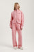 Person wearing a pink tracksuit with 'SET' branding on a white background