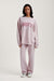 Person wearing a pink 'SET' sweatshirt and pants on a white background