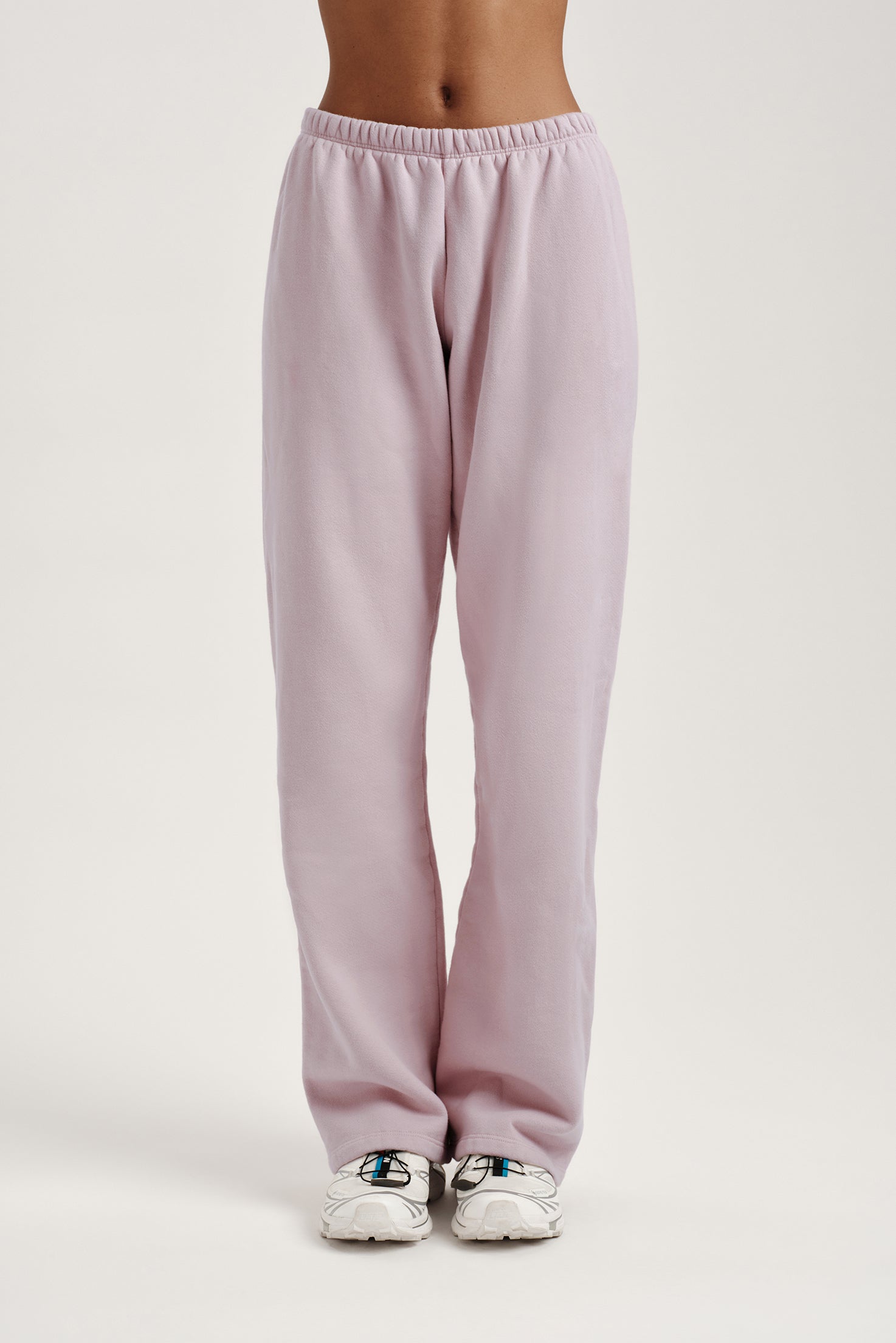 Light pink sweatpants worn by a person on a light gray background