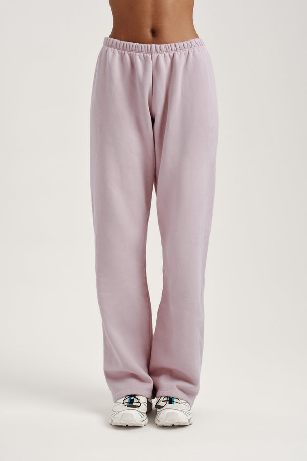 Light pink sweatpants worn by a person on a light gray background