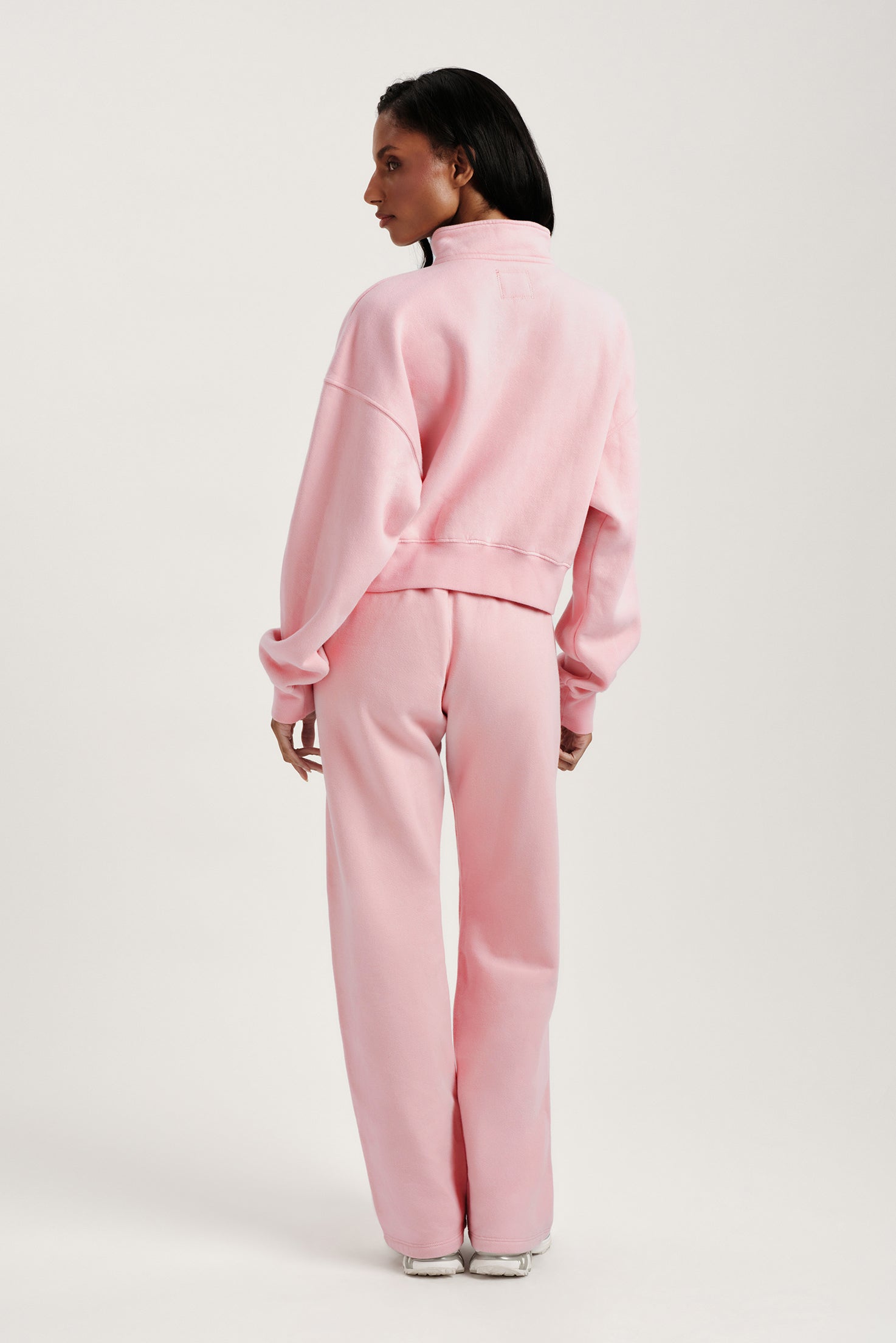 Person wearing a pink tracksuit on a white background