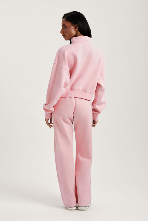 Person wearing a pink tracksuit on a white background