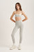 Woman wearing a light gray sports bra and leggings set on a white background