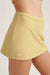 Yellow athletic skirt with 'SET' branding on a light background