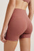 Maroon athletic shorts worn by a person on a light beige background