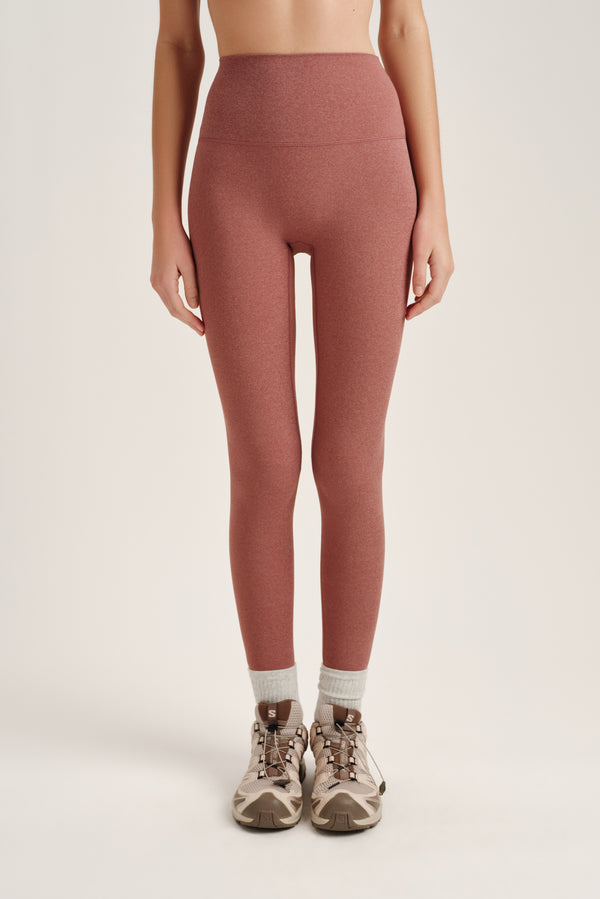 Person wearing pink leggings on a plain background 