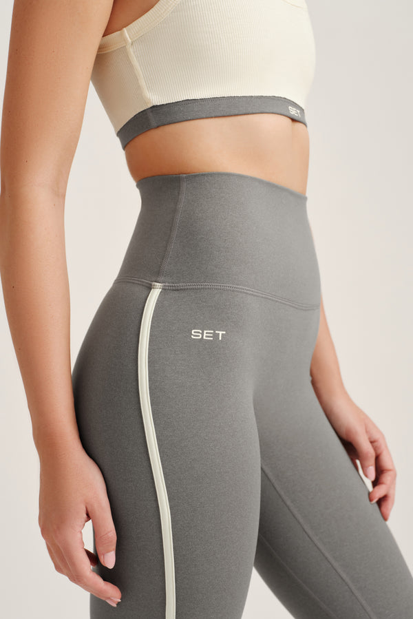 Gray leggings with a white stripe and 'SET' branding on a neutral background