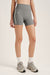 Person wearing gray athletic shorts with a visible brand logo on a white background <model-info>Bella wears a size XS and is 5’7, 23” waist, 32AB bust.</model-info>